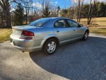 2005 Dodge Stratus SXT in Satin Jade Pearl color, parked on a gravel driveway, showcasing its clean exterior.