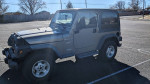 2002 Jeep Wrangler for sale, gray color, parked, in good condition with minor wear.