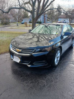 2015 Chevrolet Impala in black with leatherette interior, parked in a residential area.