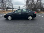 2010 Ford Focus SES in excellent condition, parked on a paved surface with a natural backdrop.