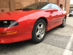 1997 Chevrolet Camaro RS in pristine red condition with polished rims and no rust, showcasing perfect body and interior.