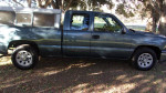 Side view of a well-maintained Chevrolet Silverado 1500 pickup truck with a camper shell, 97,000 miles.