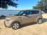 2016 Kia Soul in excellent condition parked by a lake, with clear skies and trees in the background.