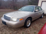 1998 Ford Crown Victoria LX in gold color, well-maintained and garage kept, with low mileage of 125,000 miles.