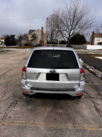 Rear view of a 2011 Subaru Forester 2.5X AWD parked, showcasing its premium design and features.