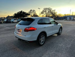 2013 Porsche Cayenne in excellent condition, white exterior, tan interior, viewed from the rear at sunset.