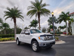 2011 Ford F-150 King Ranch 4WD parked beside palm trees, showcasing its excellent condition and design.