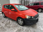 2012 Chevrolet Sonic in bright orange, well-maintained, 110,000 miles, parked on snowy ground
