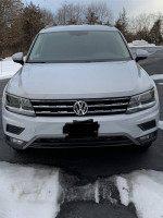 Front view of a 2018 Volkswagen Tiguan in white, showcasing its sleek design and all-wheel drive features.