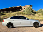 2011 BMW 328i E90 in titanium silver parked in a scenic outdoor location