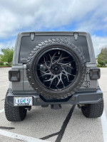 Rear view of a customized 2019 Jeep Wrangler Unlimited Moab showing black rims and off-road tires.