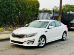 2015 Kia Optima LX in white parked on street, highlighting clean exterior and alloy wheels.