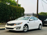 2015 Kia Optima LX FWD in white with alloy wheels, parked on street, showcasing its clean design and exterior