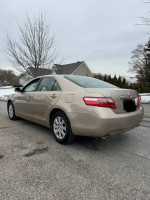 2007 Toyota Camry XLE in light beige color, featuring a clean exterior and parking lot background.