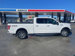2018 Ford F-150 XLT 4WD parked at a gas station, showcasing its sleek design and new tires.