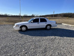 2008 Grand Marquis LS sedan in white, parked on gravel with scenic background.