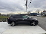 Side view of a 2015 Chevrolet Traverse LT AWD parked on a concrete surface, showcasing its sleek design.