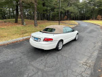 2006 Chrysler Sebring Touring Edition, white convertible parked on a road, showcasing its elegant design.