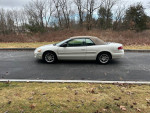 2006 Chrysler Sebring Touring Edition parked on a road, showcasing its white color and convertible top.
