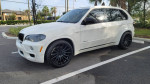 2010 BMW X5 parked, featuring new Vossen 22-inch wheels and clean exterior in a sunny setting.