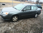 2005 Chevrolet Malibu LS in gray color, parked on gravel, showcasing its exterior and detailing.