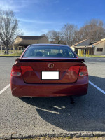 2007 Honda Civic Si rear view, red color, showing good condition with some minor cosmetic damage.