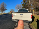 Rear view of a silver Ford F150 4x4 Ecoboost truck on a sunny day, showcasing its clean exterior.