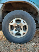 Close-up of a tire on a 2000 Nissan Xterra SE RWD, showing good condition for off-road driving.