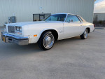Classic 1977 Cutlass Supreme in mint condition, white exterior, well-maintained, one owner, V8 engine.