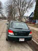 2004 Subaru Impreza station wagon parked on a residential street, great shape with 150,000 miles.