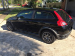 2010 Volvo C30 in black with Sparco wheels parked on the street, showing its sporty design and condition.