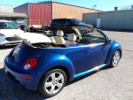 Blue 2007 Volkswagen Beetle convertible with beige interior parked outdoors, showcasing its sporty design.