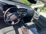 Interior view of a 2018 GMC Canyon SLE 4WD with touch screen and leather seats.