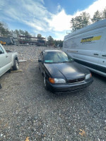 1997 Toyota Tercel parked in gravel, showcasing its black exterior and reliable performance for sale.
