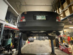 1997 Toyota Tercel on a lift in a garage, showcasing its rear and new exhaust system.