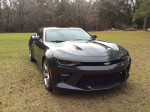 2016 Chevrolet Camaro SS in Midnight Charcoal Metallic Gray parked on grass, showcasing its sleek design.