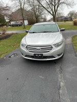2013 Ford Taurus Limited FWD parked on driveway with visible wear and repairs needed.