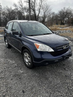 2009 Honda CR-V in blue, with all-wheel drive, spacious trunk, and Kenwood stereo on a gravel surface.
