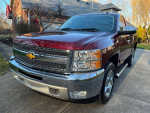 2013 Chevrolet Silverado 1500 in Deep Ruby color with chrome accents and new tires parked in front of a house