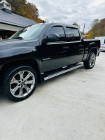 2010 GMC Sierra Denali 1500 in black, featuring sleek design and shiny wheels, parked outdoors