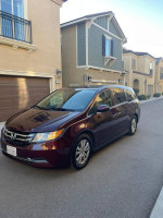 2014 Honda Odyssey EXL in excellent condition parked in a residential area, featuring leather interior and new tires.