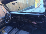 Interior view of a 1985 Jeep CJ7 Renegade with original steering wheel and dashboard.
