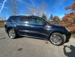 2012 GMC Acadia Denali in excellent condition, showcasing its sleek design and shiny wheels on a clear day.