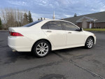 2007 Acura TSX in white with low mileage parked on a paved lot, featuring stylish alloy wheels and sleek design