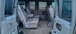 Interior view of 2004 Chevrolet Express 1500 AWD showcasing four leather captain's chairs and power folding rear bench seat.
