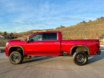 2020 GMC Denali HD Crew Cab truck in Red Quartz Tintcoat with off-road tires and a 4-inch lift kit