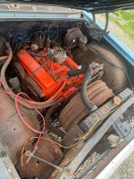 View of the engine compartment of a 1963 Chevrolet Impala Convertible with a 283 engine and visible minor rust.