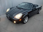 2003 Toyota MR2 Spyder convertible parked, showcasing its sleek black exterior and sporty design.