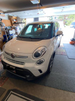 White 2014 Fiat 500L Trekking parked in a garage, featuring a stylish design and low mileage.