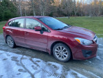 2012 Subaru Impreza hatchback in dusty condition parked on a dirt road with scenic background.